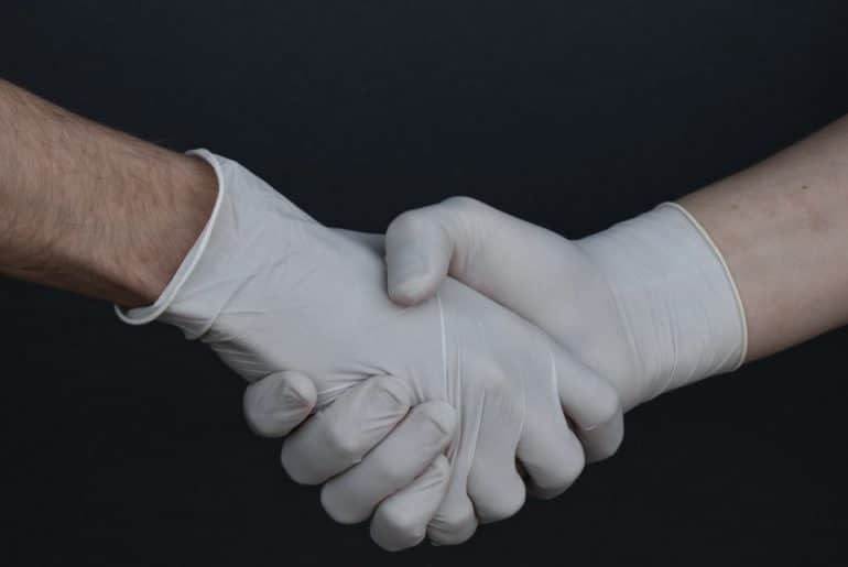 holding hands with protective gloves - salud