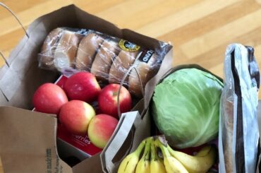 bolsas de comestibles con manzanas, plátanos, bagels y lechuga - Compras