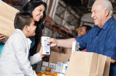 Niño y madre donando comida en una despensa - Encuentra comida sin cargo