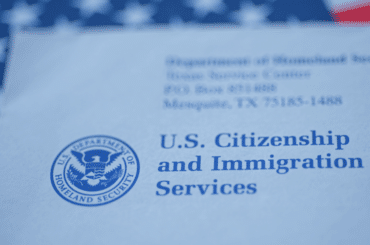 Sobre de USCIS con la bandera estadounidense atrás - Advance Parole