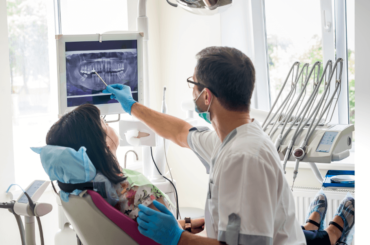 Dentista mostrando los dientes del paciente en rayos X - Atención dental asequible cerca de ti