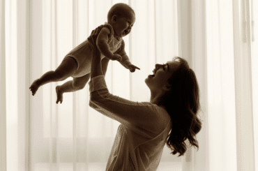 Madre sonriente con bebé en sus brazos - Ayuda para madres solteras en EE.UU.