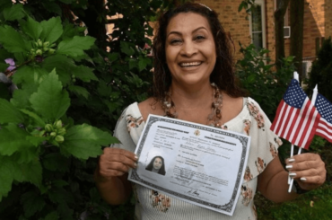 Mujer sosteniendo un certificado de naturalización - Recursos para examen de ciudadanía