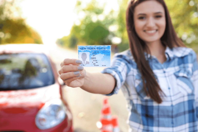 Pasa el examen de conducción - Mujer feliz sosteniendo su licencia de conducción
